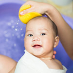 Baby being washed with a sponge without irritants found in baby products