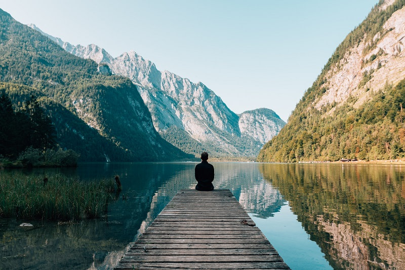 Man sitting on a dock in nature
