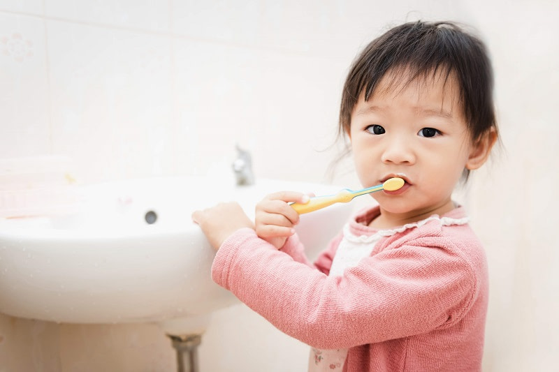 Sweet girl brushing her teeth